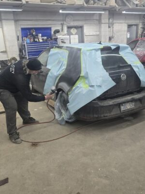 Mid City Collision Image 11 Applying auto primer to car